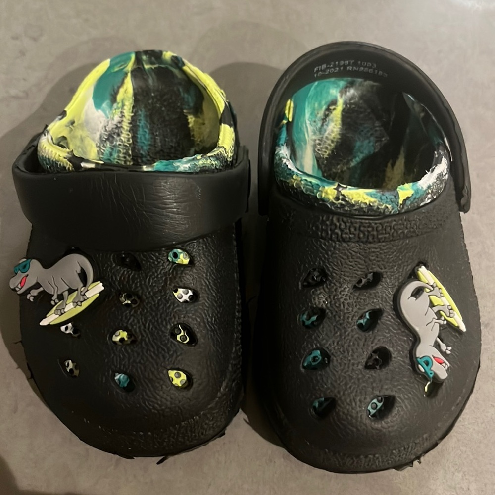 Size 5 baby crocs black an green with two fit bits